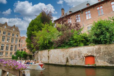 Tarihi şehir merkezinde ortaçağ mimarisi, kaldırım taşı sokakları, gotik kuleler ve canlı çiçek sergilerinin yer aldığı Bruges, Belçika 'nın resimli manzarası.
