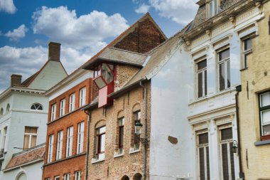 Tarihi şehir merkezinde ortaçağ mimarisi, kaldırım taşı sokakları, gotik kuleler ve canlı çiçek sergilerinin yer aldığı Bruges, Belçika 'nın resimli manzarası.