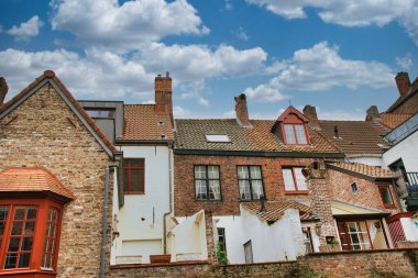 Tarihi şehir merkezinde ortaçağ mimarisi, kaldırım taşı sokakları, gotik kuleler ve canlı çiçek sergilerinin yer aldığı Bruges, Belçika 'nın resimli manzarası.