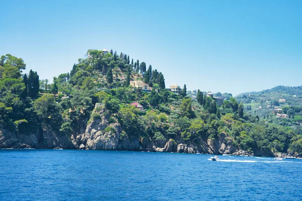 İtalya 'nın Ligurian kıyısındaki mavi Akdeniz üzerinde yeşil tepeleri ve villaları olan Rocky sahili..