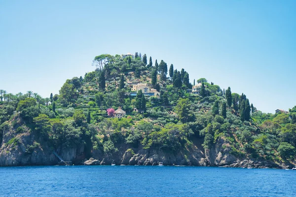 İtalya 'nın Ligurian kıyısındaki mavi Akdeniz üzerinde yeşil tepeleri ve villaları olan Rocky sahili..