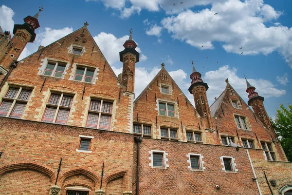 Tarihi şehir merkezinde ortaçağ mimarisi, kaldırım taşı sokakları, gotik kuleler ve canlı çiçek sergilerinin yer aldığı Bruges, Belçika 'nın resimli manzarası.