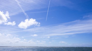 Dynamische Wolken auf blauem Himmel ueber Nordsee-Panorama