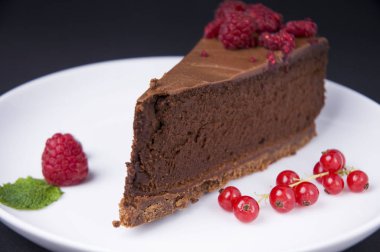 Koyu arka planda çilek ile çikolata cheesecake Parçası