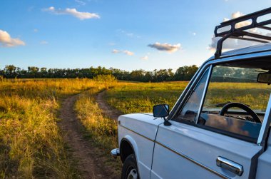 Kırsal bir yolda gün batımında beyaz eski araba