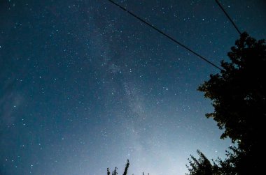 Samanyolu ağaçlar ile bir arka plan üzerinde köyde