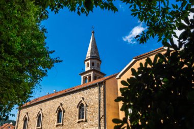 Ağaçların arkasından kilisenin güzel manzarası, doğru kompozisyon temiz gün, budva monthe gro