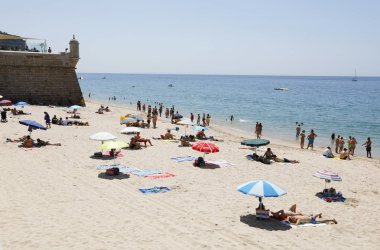 Sesimbra, Setubal, Portekiz - 29 Haziran 2019: Portekiz'in Setubal ilçesinde, Sesimbra Köyü'nün bir plajı olan Praia do Ouro'da turistler eğlenir.