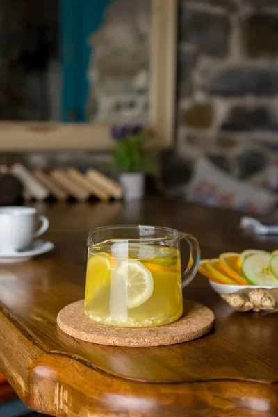 Hot lemon and apple tea with spices in a glass teapot.