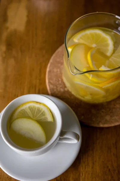 Hot lemon and apple tea with spices in a glass teapot.