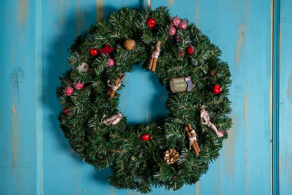 Ahşap kapıya süslemeli Noel çelengi. Noel ağacı, hediyeler, yeni yıl. İyi tatiller..
