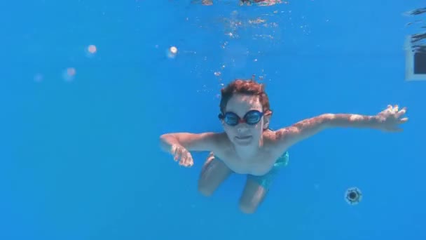 Fröhlicher lustiger Junge springt und springt ins Schwimmbad — Stockvideo