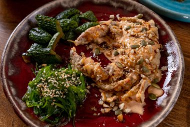 Lezzetli pişmiş yengeç, baharatlı sos ve chuka yosunu.