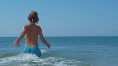 Çocuk deniz kenarında yaz tatilinin tadını çıkar..