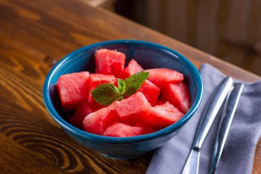 Dilimlenmiş taze karpuz manzarası. Karpuz dilimleri, ahşap masadaki tabak parçaları. Yaz taze doğa atıştırması. Seçici odaklanma. Dikey çekim