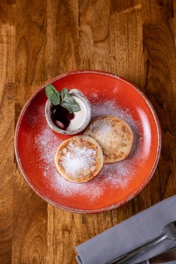 Tahta masada kırmızı tabakta peynirli tatlı. Kafede nefis bir kahvaltı. Ev yapımı fırın. Yemek fotoğrafı..