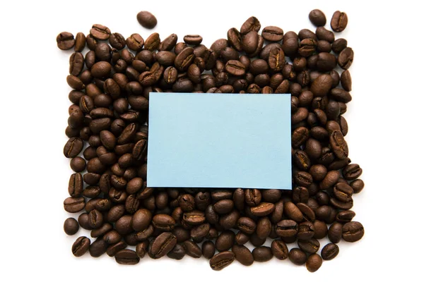 多くのコーヒー豆のしっかりした背景に青いノートのモックアップ 白い背景に隔離され テキストのコピースペース — ストック写真