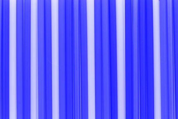 A solid background of many plastic colored straws arranged in a row