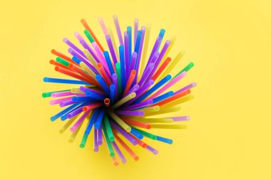 Çeşitli plastik pipetlerden havai fişekler ya da havai fişekler. Sarı arka planda izole edilmiş.