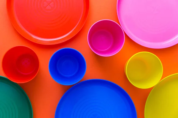 아이들은 수없는 색깔의 접시를 가지고 아이들의 휴일에 합니다 주황색 배경에서 스톡 사진
