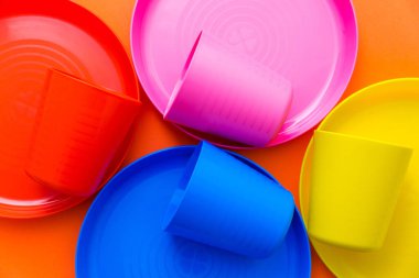 Çocukların rengarenk tabakları, çocuk tatili için servis ediliyor. Turuncu bir arka planda izole edilmiş.