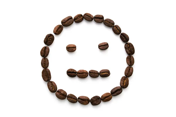 Una imagen de una cara sonriente indiferente hecha de muchos granos de café. Aislado sobre un fondo blanco — Foto de Stock