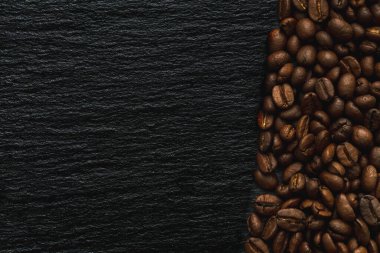 Kayrak taşından siyah desenli arka planda bir sürü kahve çekirdeği bandı. Metin için alanı kopyala