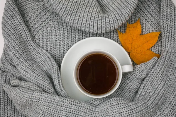 Een stapel heldere herfstbladeren en een kopje warme thee op een gebreide trui achtergrond. Platvis — Stockfoto