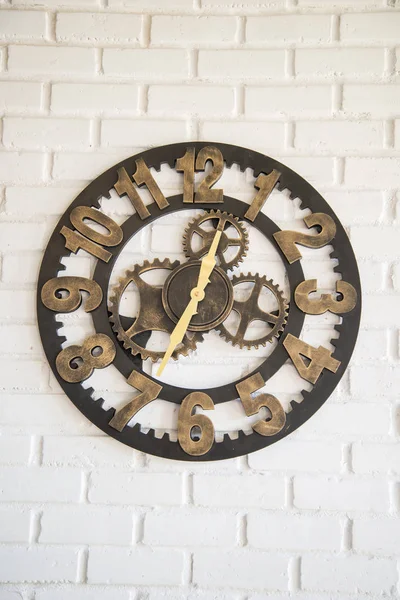 Clock mechanism on the white wall of the coffee shop.
