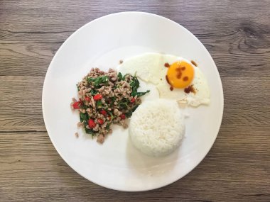 Fesleğen soslu baharatlı kızarmış domuz eti bırakır ve kızarmış yumurta.