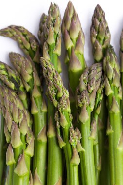 Beyaz arkaplanda taze çiğ apsaragus mızrakları