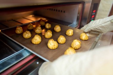 Fırıncı fırında ekmek pişirmeye hazırlanıyor. Fırın, taze pişmiş bir kabuğu yakın tutuyor. Ailesiyle birlikte karantina evindeki etkinlik sırasında..