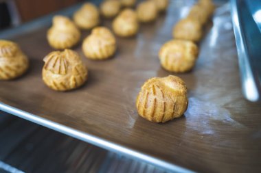 Choux 'un pişirdiği ev, taze çıtır ekler ve profiteroller yapmış. Endüstriyel ölçekte tatlı ve tatlı yapmak, endüstri, arka plan. Choux geleneksel bir Fransız tatlısıdır..