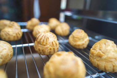 Choux 'un pişirdiği ev, taze çıtır ekler ve profiteroller yapmış. Endüstriyel ölçekte tatlı ve tatlı yapmak, endüstri, arka plan. Choux geleneksel bir Fransız tatlısıdır..