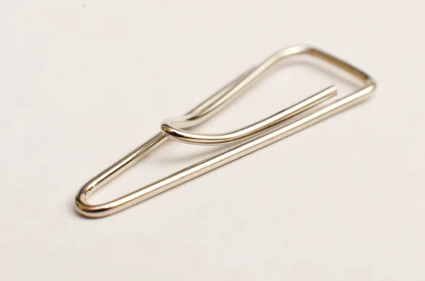 Paper clips, made of iron, are curved in a white background