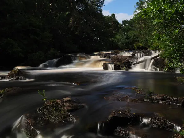 İskoç Highlands güneş ışığında mistik şelale