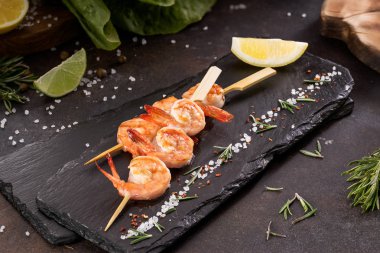 Tuz, otlar, limon ve kireç ile şiş üzerinde ızgara karides