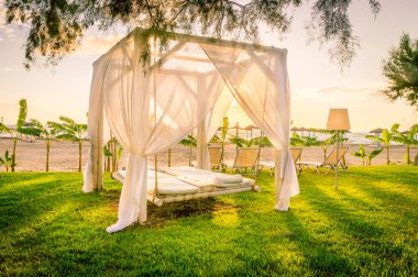 Sunrise adlı Yunan sahil şeridi üzerinde beyaz sunlounger