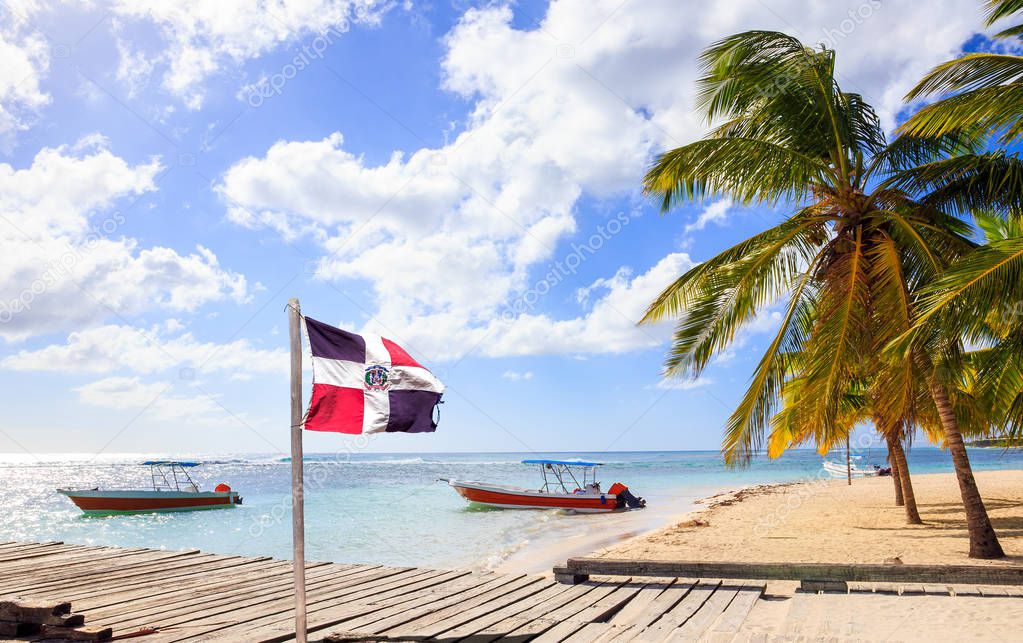 Caribbean beach and Dominican Republic flag on Saona island