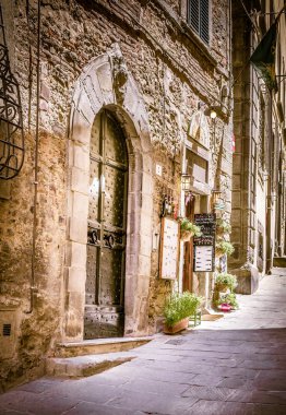 Cortona, İtalya - 26 Haziran 2015: Küçük dükkanında Toskana bölgesindeki eski Cortona şehrin büyüleyici dar sokak