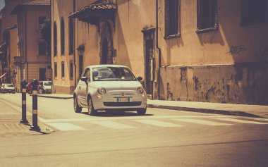 AREZZO, ITALY - JUNE 26, 2015: The newest version of Fiat 500, one of the most popular small city cars in Italy, on cross roads in tuscan Arezzo city, Italy clipart