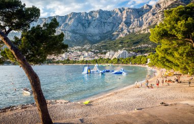 Makarska, Hırvatistan - 14 Temmuz 2018: İnsanlar rahatlatıcı Makarska Plajı gün batımında, Hırvatistan