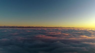 Sıcak turuncu akşam güneş ışığında beyaz kabarık bulutlar dolu günbatımı gökyüzü üzerinde Harika 4k havadan drone uçuş