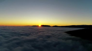 Sıcak turuncu akşam güneş ışığında beyaz kabarık bulutlar dolu gün batımı gökyüzü üzerinde Muhteşem 4k havadan drone uçuş