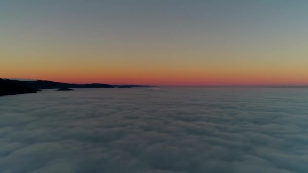 暖かいオレンジ色の夕日の光の白いふわふわの雲の完全な夕日の空の上に絵のような4K空中ドローン飛行 — ストック動画