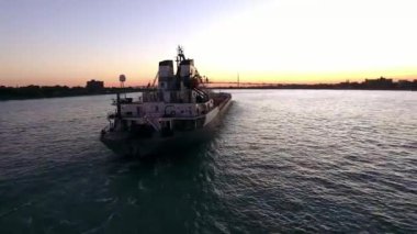 Konteyner yük kargo tanker gemi çarpıcı 4k hava drone görünümünde pembe günbatımı deniz manzarası okyanus suyunda yavaş yelken