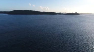 Derin mavi sakin okyanus su deniz manzarası ortasında büyük orman dağ tropikal adada Inanılmaz 4k havadan drone görünümü