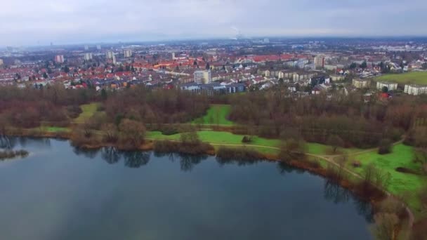 Superbe vol aérien de drone 4k au-dessus d'un petit paysage urbain calme avec grand lac miroir de surface dans le parc par temps nuageux 
