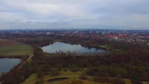 Vol aérien pittoresque de drone de 4k au-dessus du petit paysage urbain calme avec le grand lac de surface de miroir dans le parc par jour nuageux 