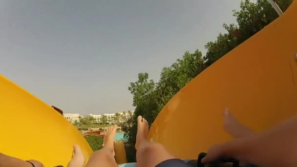 Point de vue de la première personne tout en glissant vers le bas de la glissière hydraulique colorée aquapark avec le tube gonflable éclaboussant l'eau 4k 